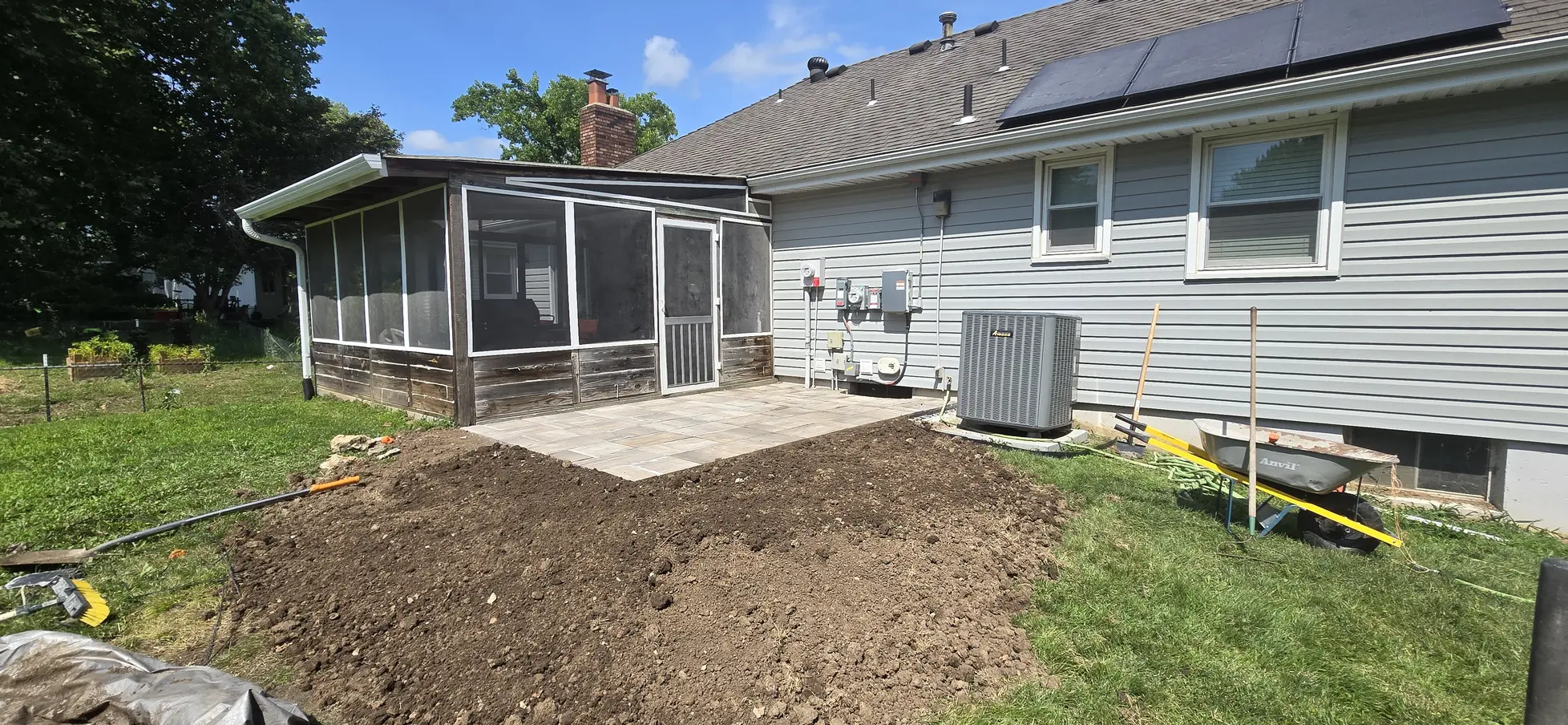 Completed paver patio beside the screened porch before surrounding soil was regraded