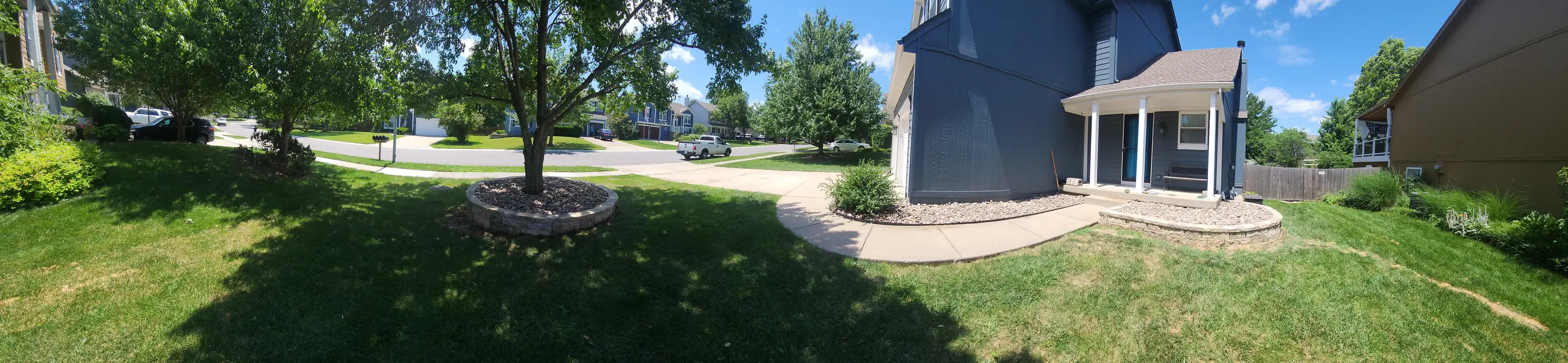 Wide finished view of the tree ring and front stone landscape beds
